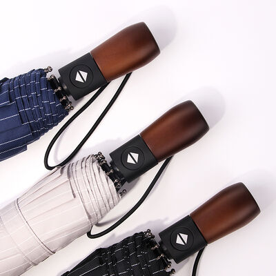 Un parapluie 3 fois pliable, ouverte et fermée automatiquement, avec poignée en bois